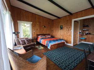 1 dormitorio con 1 cama, mesa y sillas en The Lodge at Reventazon River Mountain Ranch, en Turrialba