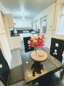 a vase of flowers on a table in a kitchen at SwankyHome4Groups/Contractors/M5 in Dudley