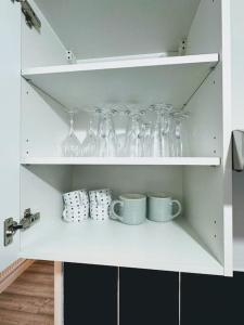 a white cabinet with wine glasses and cups on it at SwankyHome4Groups/Contractors/M5 in Dudley