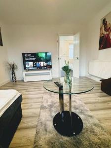 - un salon avec une table en verre et une télévision dans l'établissement SwankyHome4Groups/Contractors/M5, à Dudley