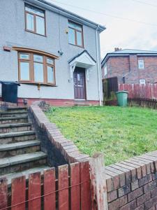 a house with a brick retaining wall and stairs at SwankyHome4Groups/Contractors/M5 in Dudley