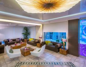 un vestíbulo con sofás, mesas y una lámpara de araña en KAKTUS Hotel Kaktus Playa - Adults Recommended, en Calella