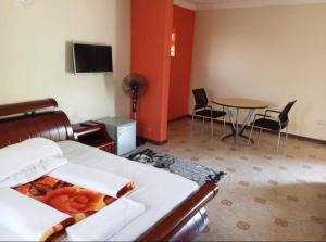 Habitación de hotel con cama, mesa y sillas en Migingo Suites, en Entebbe