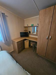 a bedroom with a desk with a computer and a bed at Oak Green in Gristhorpe