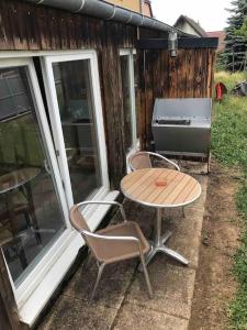 een patio met een tafel en stoelen en een grill bij Logement avec piscine in Brunstatt