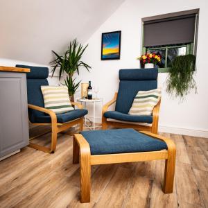 ein Wohnzimmer mit blauen Stühlen und einem Kamin in der Unterkunft Cwtch Lackerlee in Haverfordwest