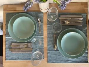 a table with two green plates and silverware at Hotel Buchberg - Moderne Design-Apartments in Bermatingen