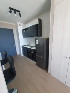 a kitchen with a black refrigerator and a black stove at Studio Chillan Centro in Chillán