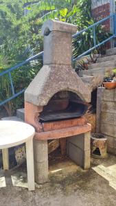 un forno in pietra seduto accanto a un tavolo di Rosekayen a Capesterre-Belle-Eau