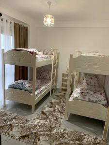 een kamer met 2 stapelbedden en een kroonluchter bij Ridi's Comfort Apartment 2 in Shkodër