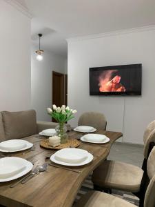 een eetkamer met een houten tafel met stoelen bij Ridi's Comfort Apartment 2 in Shkodër