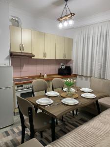 een keuken met een houten tafel met stoelen en een eetkamer bij Ridi's Comfort Apartment 2 in Shkodër