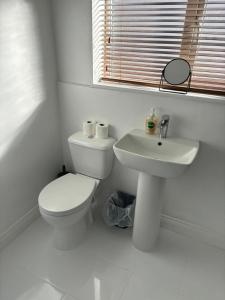 a white bathroom with a toilet and a sink at Nanny and Chips House in Whitby