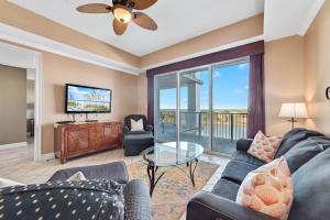 un soggiorno con un divano e una TV di The Wharf Unit 717 a Orange Beach