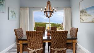 a dining room with a table and chairs and a window at Luau II 7023 in Destin