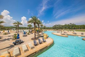 una piscina in un resort con sedie e palme di The Wharf Unit 717 a Orange Beach