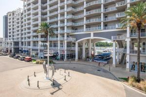 una statua di fronte a un grande edificio di The Wharf Unit 717 a Orange Beach
