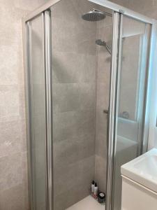 a shower with a glass door in a bathroom at Ideal apartamento con terraza en Bernabeu in Madrid