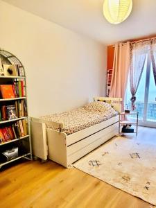 een slaapkamer met een bed en een boekenplank bij Grand appartement avec jardin calme et lumineux in Saint-Ouen