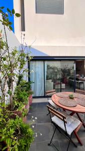 un patio con mesa, sillas y algunas plantas en Welcome to your happy place ! en Dar Bouazza