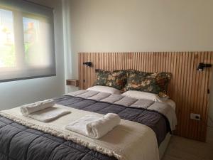 1 dormitorio con 1 cama con toallas en CyclosApart en Esquel