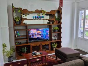 a living room with a flat screen tv on a wooden entertainment center at JetPoint Holiday Home in Nadi