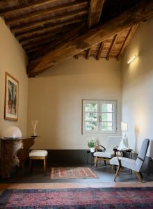 a living room with wooden ceilings and a table and chairs at Ca' Bianca Tuscany Relais in Siena