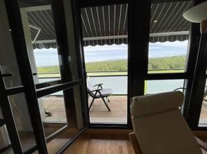 Sala de estar con silla y vistas al océano en Mirador Rioja alta golf, en Cirueña