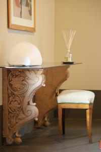 uma secretária com um banco e uma mesa com uma tigela em cima em Ca' Bianca Tuscany Relais em Siena