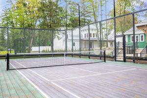 una pista de tenis con red y algunas casas en The Pool House at Fr. Sorin's w/ Paddle Tennis, en South Bend