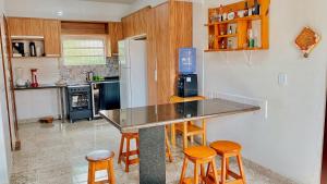 a kitchen with a counter and some stools in it at Lar Lalunalê 3 in Prado +4 photos