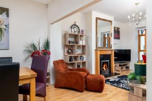 a living room with a chair and a fireplace at Shannonside - Stylish 5 Bed Marina home & 40ft mooring in Termonbarry