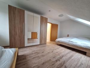 a bedroom with two beds and a large cabinet at FeWo BlackForest in Neuenburg am Rhein