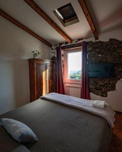 a bedroom with a large bed with a window at Vezzhouse con Convenzione per Spa & Wellness in Vezzano Ligure