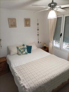プラヤ・フラメンカにあるEl Rincon & La Calma Vacation Paradiseのベッドルーム1室(白いベッド1台、天井ファン付)
