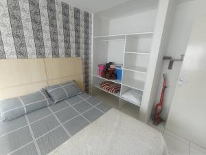 Dormitorio pequeño con cama y armario en Apto espaçoso uma quadra do mar com garagem, en Balneário Camboriú