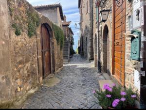 an alley with buildings and flowers on a street at La Rosa del lago in Bracciano