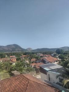 Blick auf eine Stadt mit Bergen im Hintergrund in der Unterkunft Espaço Verano- quarto Família in Niterói