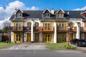 a large house with yellow doors and a car parked in front at Shannonside - Stylish 5 Bed Marina home & 40ft mooring in Termonbarry