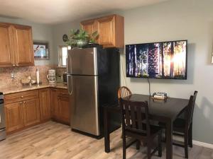 a kitchen with a stainless steel refrigerator and a table at Pelican Place in Morro Bay in Morro Bay