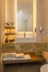 een badkamer met een wastafel, een spiegel en handdoeken bij Ema Houses in Antalya