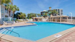 a large swimming pool with palm trees and buildings at Beachside Two 4278 in Destin