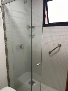 a glass shower door in a bathroom with a toilet at Sun Square Suítes Hotel By Lual in Goiânia
