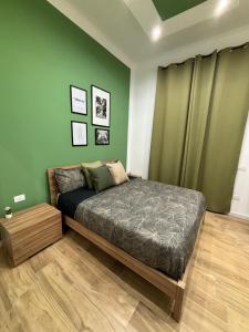 1 dormitorio con cama y pared verde en Salotto Mariella en Nápoles