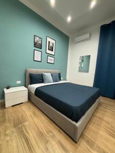 um quarto com uma cama grande e paredes azuis em Salotto Mariella em Nápoles