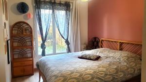 een slaapkamer met een bed en een groot raam bij Grand appartement avec jardin calme et lumineux in Saint-Ouen