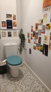 een badkamer met een toilet en foto's aan de muur bij Grand appartement avec jardin calme et lumineux in Saint-Ouen