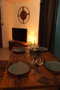 een houten tafel met borden en wijnglazen erop bij Appartement centre ville de Pierrelatte' in Pierrelatte