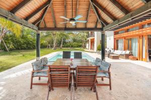 a patio with a table and chairs and a pool at Amazing 5br villa w pool at Green Village A in Punta Cana