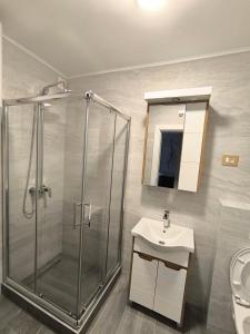een badkamer met een douche, een wastafel en een spiegel bij Spa Tesla 1 in Batajnica